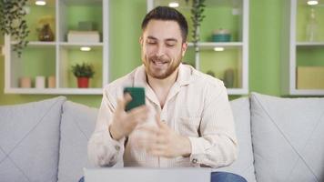 a homem Falando em a telefone estava feliz com a notícia ele recebido. homem sentado às casa sorridente e alegria às Boa notícia enquanto falando em a telefone. video