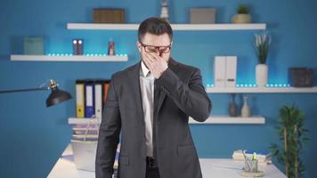 müde Geschäftsmann im Büro Leiden von Kopfschmerzen und Auge Schmerz. Geschäftsmann hat Schmerzen im seine Kopf und Augen weil er ist sehr müde. das Mann ist Reiben seine Kopf. video