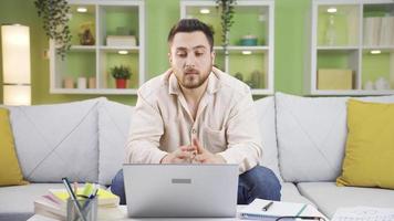 nervoso giovane uomo pensa di che cosa per fare a il computer e prende stressato. uomo in piedi nel davanti di il computer portatile a casa guardare in giro stressato e premuroso. video