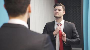 el joven hombre quien es tarde para trabajo preparado en frente de el espejo con pánico y estrés. video