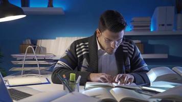 Researcher man working with historical archives and scientific books in his study. The young researcher is astonished when he learns new information about the subject he is investigating in the study. video