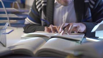 profesional historiador trabajos con científico libros en su estudiar, toma notas de cerca de mayor investigador hombre leyendo libro, haciendo investigación en estudiar habitación. video