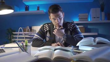 A researcher who conducts scientific research in a planned and systematic way. Researcher young man reading historical and scientific books in his study, researching new topics. video