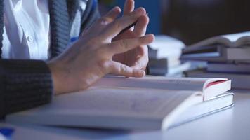 de cerca de masculino haciendo investigación en científico libro. de cerca de joven hombre leyendo un libro, haciendo investigación, coleccionar información. video