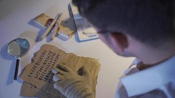 el historiador hombre quien investigado y traducido el histórico letra escrito en tinta. historiador hombre estudiando y investigando el antiguo carta. video