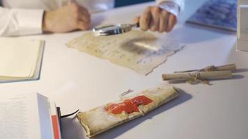 Close-up of historian man examining and researching letter written in Ancient Alphabet. video