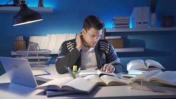 The scientific researcher collects information from books in his research. Young researcher male reading book in Study Room collecting information and data source. video