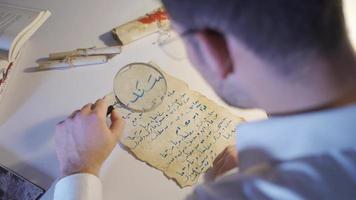 The epigraphist examines the letter written in the medieval Arabic script. Epigraphist examining a letter written for communication in the Middle Ages. video