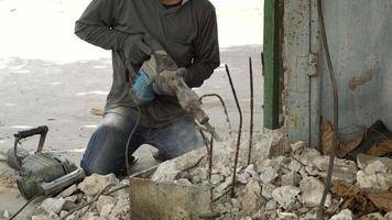 construcción trabajadores utilizando perforar es trabajando en hormigón estructuras a el construcción sitio de construcción y industria concepto video