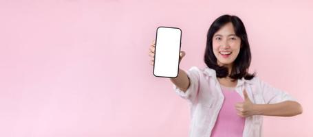 contento sonriente joven asiático mujer recomendando demostración nuevo solicitud o móvil anuncio publicitario, Bosquejo teléfono inteligente modelo bandera aislado en rosado antecedentes. collage blanco pantalla digital móvil dispositivo.
