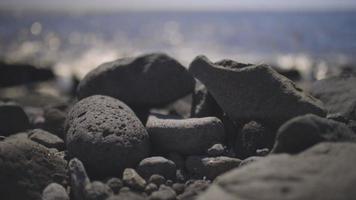 een vulkanisch rots strand met extreem bokeh en mooi hoor uit van focus gebieden video