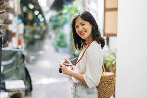 Portrait of asian woman traveler using camera at street of Bangkok, Thailand. Asia summer tourism vacation concept photo