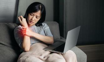 asiático mujer tiene brazo dolor. hembra participación doloroso brazo con otro mano. personas con músculos del cuerpo problema, cuidado de la salud y medicamento. foto