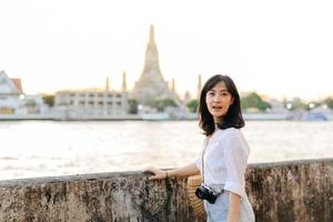 Portrait young beautiful asian woman smiling while travel at Wat Arun sunset view point, Bangkok, Thailand. photo