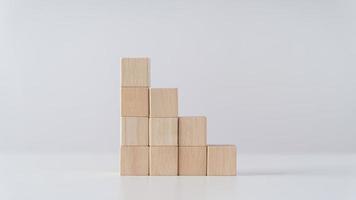 Pile of wooden cube block stack as stair step on the table. Success, climbing to the top, Progression, business growth concept. photo