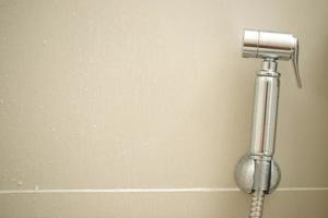 Cleaning staff examining the toilet sprayer. photo