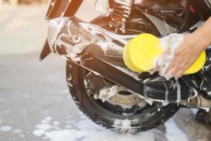 el trabajador es Lavado el motocicleta a coche cuidado. foto