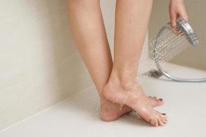 woman using shower to clean feet photo