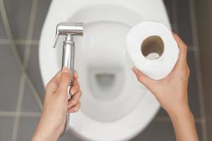 Cleaning staff examining the toilet sprayer. photo