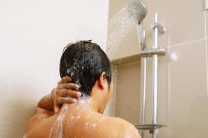 un hombre es utilizando ducha crema para seco piel devoluciones piel a ser suave, hidratado y nutrido foto