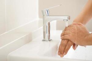 higiene. limpieza de manos. lavarse las manos con jabón debajo del grifo con agua paga suciedad. foto