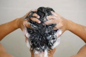 A man is washing his hair with shampoo photo