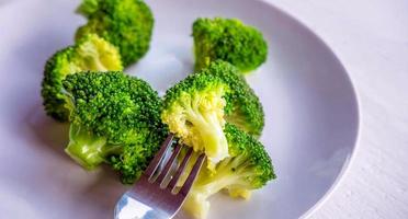 Close-up of green fresh vegetable broccoli. Fresh green broccoli on plate. Broccoli vegetable is full of health. Vegetables for diet and healthy eating.Top view photo