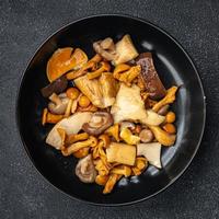 mushroom salad mix appetizer white mushroom, boletus mushroom, chanterelle mushroom, ready to eat healthy meal food snack on the table copy space food background rustic top view photo