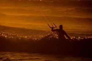 kitesurfer a puesta de sol foto