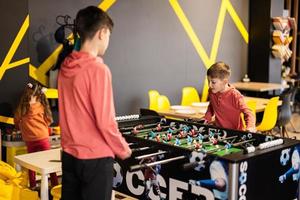 hermanos jugando mesa fútbol americano en niños jugar centro. foto