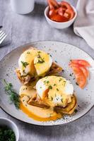 Delicious homemade breakfast with waffles, bacon and eggs benedict on a plate. Vertical view photo
