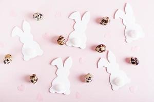 Happy easter background white rabbits, quail eggs and hearts on pink top view photo