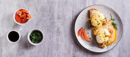 Homemade breakfast with waffles, bacon and eggs benedict on a plate. Top view. Web banner photo