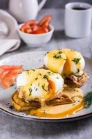 Eggs benedict and bacon on a crispy waffle on a plate for homemade breakfast. Vertical view photo