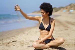 contenido negro mujer torrencial arena en apuntalar en verano foto