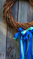 Beautiful autumnal wreath with strips on wooden background, top view. Space for text photo