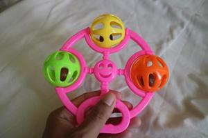 a colorful toddler toy that can make a tinkling sound with a pink handle photo