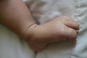 linda pies de un recién nacido bebé en un blanco colchón foto