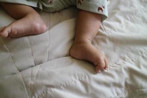 linda pies de un recién nacido bebé en un blanco colchón foto