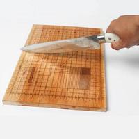 cutting board with a measuring tool and a knife on it photo