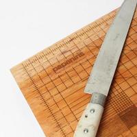 cutting board with a measuring tool and a knife on it photo