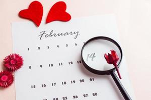 Valentine's Day. The magnifier highlights the date February 14 on the calendar sheet. Close-up photo