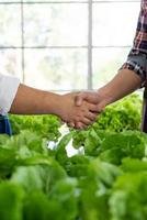 Greengrocer Making Deal with Farmer to Sell Fresh Vegetables in Market photo