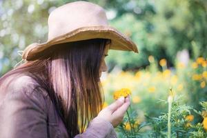 Woman and marigold flower in garden. photo