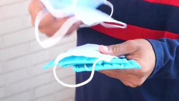 Man hand holding stack of surgical face mask, close up video