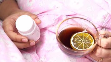 sick women holding pill container and lemon tea video