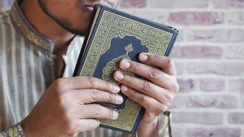 Hombre musulmán mano sujetando el libro sagrado Corán con espacio de copia video