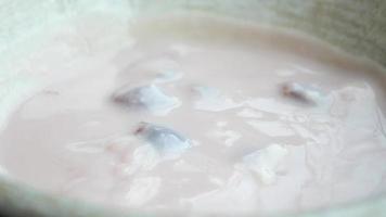 fresh fruits mixed with yogurt in a bowl on table video