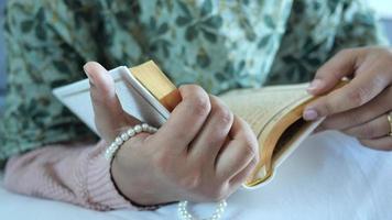 Muslim women's hand reading quran at night video