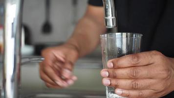 agua torrencial desde un grifo grifo en un vaso, Bebiendo puro agua concepto video